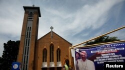 Spanduk untuk menyambut kedatangan Paus Fransiskus dipajang di gerbang katedral Notre Dame de Lingwala, di Kinshasa, Republik Demokratik Kongo, 30 Januari 2023. (REUTERS/Luc Gnago)