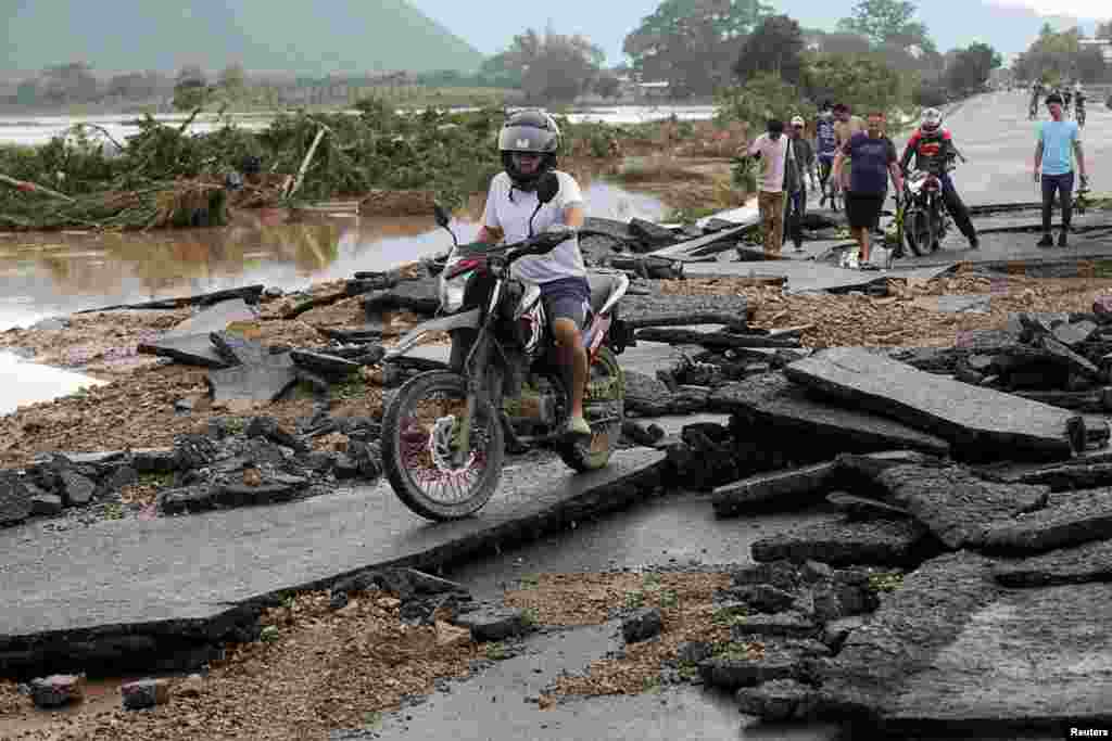 Un hombre conduce su motocicleta en un puente da&#241;ado tras el paso de la tormenta Eta, en Pimienta, Honduras, el 6 de noviembre de 2020.