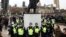 Des policiers se tiennent autour d'une statue lors d'une manifestation contre le confinement à Londres, en Grande-Bretagne, le 20 mars 2021.