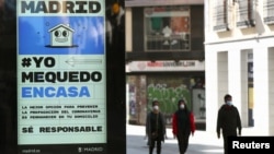 An billboard advising people to be responsible and stay home is seen at the almost empty Preciados Street, due to the coronavirus outbreak, in central Madrid, Spain, March 14, 2020.