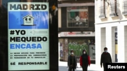 A billboard advising people to be responsible and stay home is seen at the almost empty Preciados Street, due to the coronavirus outbreak, in central Madrid, Spain, March 14, 2020.