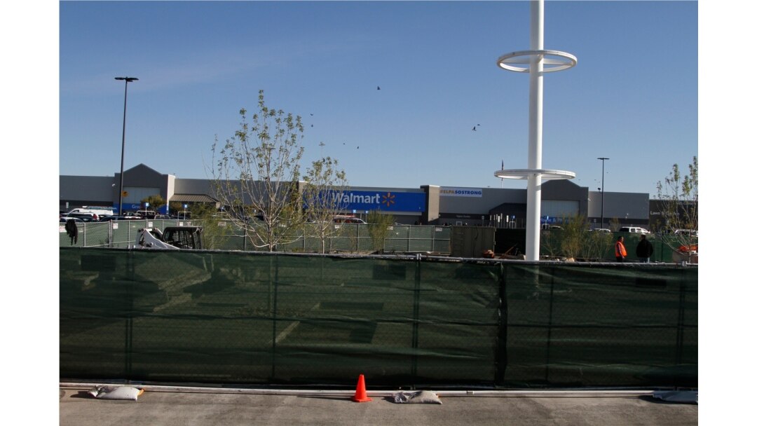 Construction workers stand near a memorial they are building for the 22 people killed at the Cielo Vista Walmart seen in the background, Nov. 14, 2019, in El Paso, Texas, minutes before the store was reopened.