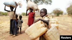 Children carry their family's belongings as they go to Yida refugee camp in South Sudan outside Tess village in the rebel-held territory of the Nuba Mountains in South Kordofan, May 2, 2012. 