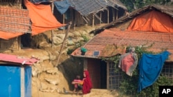 FILE - A Rohingya refugee and her child sit outside their shelter at Balukhali refugee camp near Cox's Bazar, in Bangladesh, Nov. 17, 2018. 