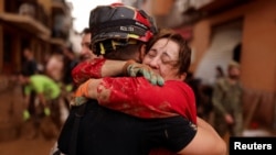 A member of Spain's Military Emergency Unit embraces with a local woman, in the aftermath of floods caused by heavy rains, in Sedavi, near Valencia, Spain, November 3, 2024. 