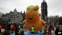 Manifestantes inflan el globo "Trump Baby" en la Plaza del Parlamento, en el centro de Londres, mientras la gente comienza a reunirse para protestar contra la visita de Estado del presidente Donald Trump, el martes 4 de junio de 2019.