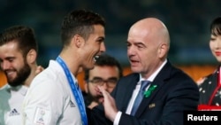 Le président de la Fifa, Gianni Infantino, à droite, congratule Cristiano Ronaldo de Real Madrid lors de la remise du trophée de la coupe du monde des clubs au stade Yokohama, Japon, 12 décembre 2016.