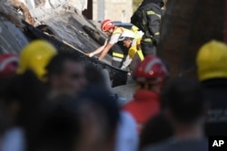 FILE - Rescue workers search for victims in the aftermath of an outdoor roof collapsed at a train station in Novi Sad, Serbia, on Nov. 1, 2024.