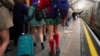 People walk along an underground station's platform as they take part in the annual event "No Trousers Tube Ride," in London, Jan. 12, 2025.