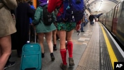 People walk along an underground station's platform as they take part in the annual event "No Trousers Tube Ride," in London, Jan. 12, 2025.