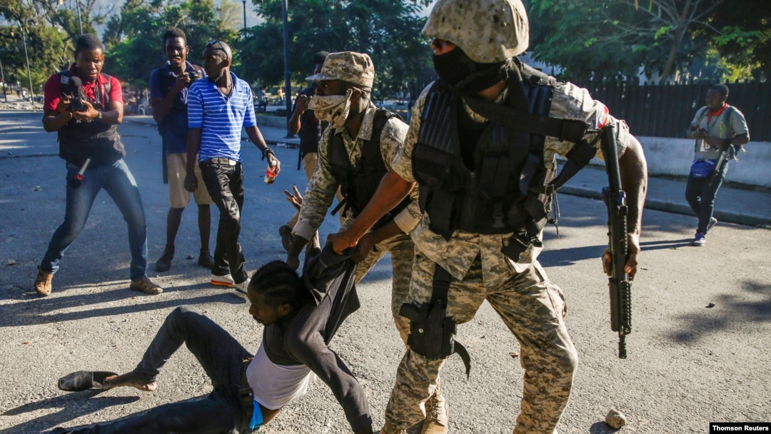 Police officers detain a man during protests against Haiti's President Jovenel Moise, in Port-au-Prince, Feb. 8, 2021.