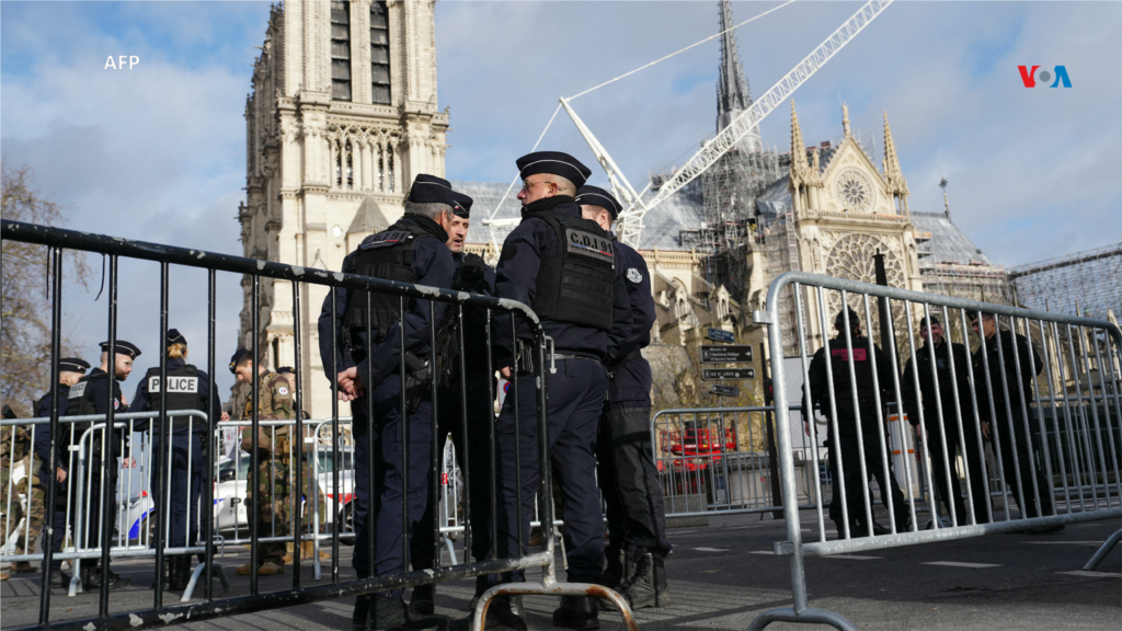 Agentes de la policía francesa patrullan dentro del perímetro de seguridad alrededor de la catedral de Notre-Dame de París, antes de su ceremonia oficial de reapertura.