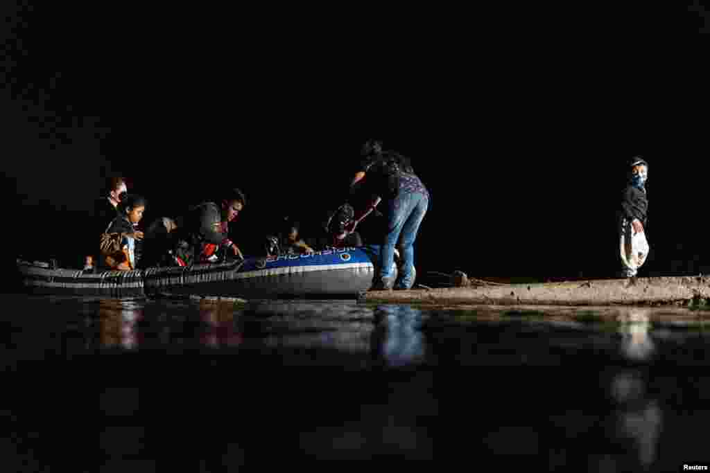 Un hombre mueve la embarcaci&#243;n hacia la tierra para que el resto de los migrantes desembarquen. 