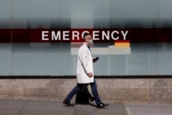FILE - A doctor wears a protective mask as he walks outside Mount Sinai Hospital in Manhattan during the outbreak of the coronavirus disease in New York City, April 1, 2020.