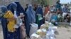 FILE - Afghan women receive food donations as part of the World Food Program (WFP) for displaced people, during the Islamic holy month of Ramadan in Jalalabad on Apr. 20, 2021.