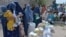 FILE - Afghan women receive food donations as part of the World Food Program (WFP) for displaced people, during the Islamic holy month of Ramadan in Jalalabad on Apr. 20, 2021.