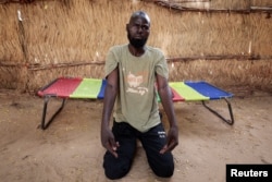 FILE - Yacoub Yahia, shows scarring on his arms which he said he sustained when captors hung him from a mango tree at a makeshift detention centre in El-Geneina in mid-June, as he speaks to journalists in Adre, Chad July 22, 2023.