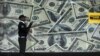 A security guard walks past a montage of old U.S. dollar bills outside a currency exchange bureau ahead of a scheduled State visit by the U.S. President Barack Obama in Kenya's capital Nairobi, July 23, 2015. 