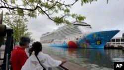 Orang-orang tampak mengamati kapal pesiar Norwegian Breakaway, di sungai Hundson, Kota New York, pada 8 Mei 2013. Sekitar 10 orang dalam kapal tersebut terinfeksi COVID-19 pada saat kapal itu berlabuh di New Orleans pada 5 Desember 2021. (Foto: AP/Richard Drew)