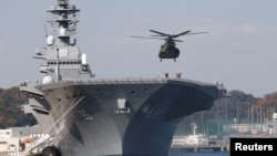 FILE - A helicopter lands on the Izumo, Japan Maritime Self Defense Force's (JMSDF) helicopter carrier, at JMSDF Yokosuka base in Yokosuka, south of Tokyo, Japan, Dec. 6, 2016. Japan plans to send one of its two large helicopter carriers to join three U.S. aircraft carriers in exercises near the Korean Peninsula.