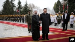 Presiden China Xi Jinping (tengah kanan) berjabat tangan dengan Presiden Iran Hassan Rouhani setibanya di istana e Saadabad, Tehrran, Iran (23/1).