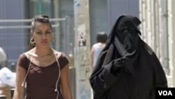 Dua perempuan Perancis di jalanan Paris. Larangan penggunaan burka di tempat umum mulai berlaku secara resmi 11 April ini.