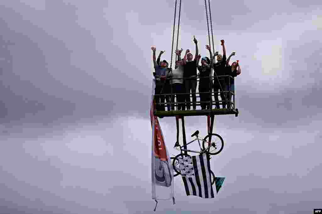 Spectators stand on a platform during the 2nd stage of the 108th edition of the Tour de France cycling race, 183 km between Perros-Guirrec and Mur de Bretagne Guerledan, France.