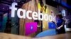 In this Tuesday, April 18, 2017, file photo, a conference worker passes a demo booth at Facebook's annual F8 developer conference in San Jose, Calif. Facebook Inc. reports earnings Wednesday, Nov. 1, 2017. (AP Photo/Noah Berger, File)