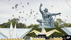 Burung merpati beterbangan di sekitar Patung Perdamaian, pada peringatan 74 tahun jatuhnya bom atom yang menandai berakhirnya Perang Dunia II, di Taman Perdamaian Nagasaki, selatan Jepang, 9 Agustus 2019. (Kyodo News via AP)