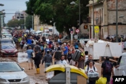 Stanovnici hodau ulicom prenoseći stvari nakon smrtonosnih bujičnih poplava u La Toreu, južno od Valensije, u istočnoj Španiji, 31. oktobra 2024.