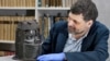Neil Curtis, head of Museums and Special Collections is seen with one of the Benin bronze depicting the Oba of Benin at The Sir Duncan Rice Library, the University of Aberdeen, Scotland, March 17, 2021. (University of Aberdeen/Handout via Reuters)