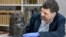 Neil Curtis, head of Museums and Special Collections is seen with one of the Benin bronze depicting the Oba of Benin at The Sir Duncan Rice Library, the University of Aberdeen, Scotland, March 17, 2021. (University of Aberdeen/Handout via Reuters)