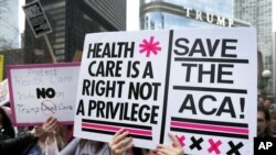 Manifestantes protestan contra la derogación de la ley de salud Obamacare desde la orilla del río Chicago al otro lado de la Torre Trump, en Chicago. Marzo 24, 2017. 