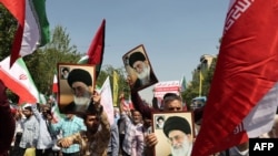 2024年4月19日，在午间祈祷后，伊朗人在德黑兰举行的反以色列示威活动中挥舞着巴勒斯坦和伊朗国旗。