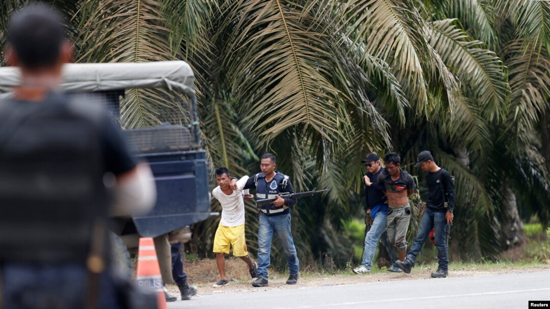 Cảnh sát Malaysia bắt giữ 2 người đàn ông tại làng Tanjung Labian, ngày 6/3/2013.