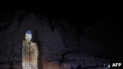 People watch a three-dimensional projection of the 56-meter-high Salsal Buddha at the place where the Buddhas of Bamiyan statues stood before being destroyed by the Taliban in March 2001, in Bamiyan province, Afghanistan.