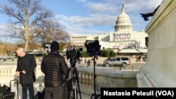 Les journalistes viennent prendre quelques images devant le Congrès, à Washington DC, le 18 janvier 2017. (VOA/Nastasia Peteuil)