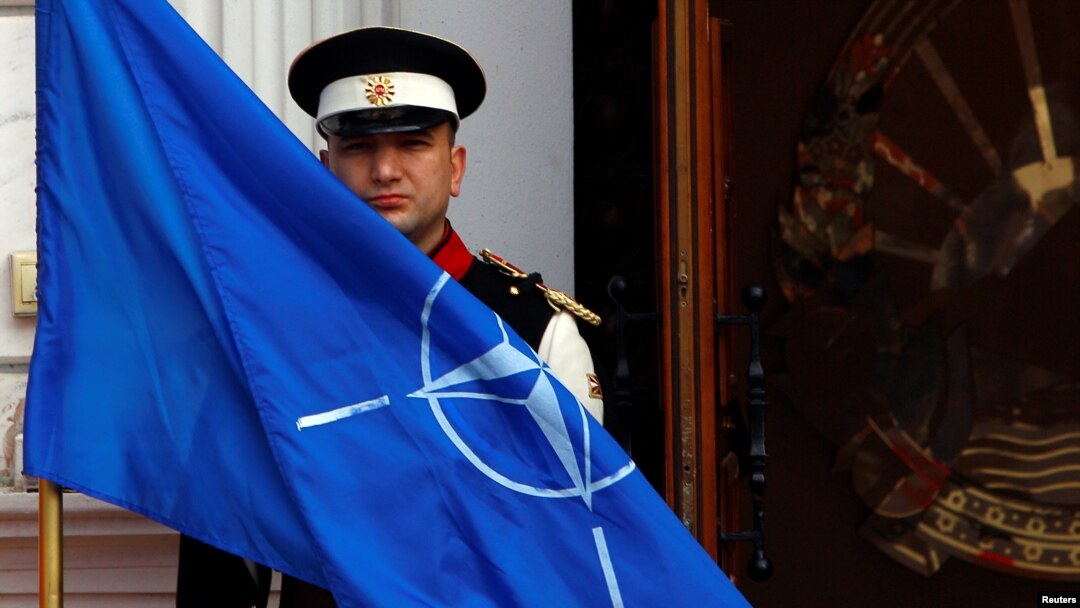 An honor guard raises the NATO flag in front of the Macedonian government in Skopje, February 12, 2019. REUTERS/Ognen Teofilovski