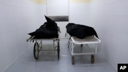 The corpses of two people who died of COVID-19 lie inside the morgue of the National Hospital Nacional, before their relatives come for them, in Itagua, Paraguay, Sept. 7, 2020.