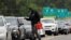 A man with a gas container is greeted by a motorist waiting in a lengthy line to enter a gasoline station during a surge in the demand for fuel following the cyberattack that crippled the Colonial Pipeline, in Durham, North Carolina, May 12, 2021.