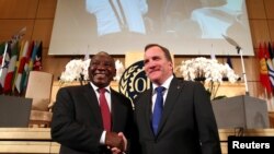 South African President Cyril Ramaphosa and Sweden's PM Stefan Lofven shake hands at the opening day of the ILO's annual conference in Geneva, June 10, 2019.