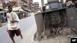 Seorang berjalan di depan instalasi listrik yang rusak di Lagos, Nigeria (foto:dok). Walaupun Nigeria memiliki cadangan energi yang besar, korupsi dan salah urus menyebabkan negara ini tidak memiliki cukup listrik.