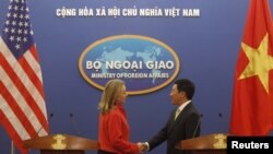 Menteri Luar Negeri AS, Hillary Clinton (kiri) berjabat tangan dengan Menteri Luar Negeri Vietnam Pham Binh Minh seusai konferensi pers di Hanoi (10/7). 