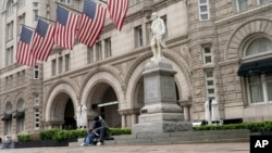 FILE - A man sits by the Old Post Office building on May 12, 2022, in Washington. The U.S. General Services Administration on March 5, 2025, took down a directory of federal property it had listed for possible sale, including the Old Post Office.