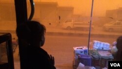 Six-year-old Mirar stares at the sandstorm while her father explains the good and bad things about the many governments that have recently ruled their town, in al-Shadady, Syria, Oct. 28, 2017. (H. Murdock/VOA)