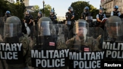 FILE - DC National Guard Military Police officers and law enforcement officers stand guard during a protests against the death in Minneapolis custody of George Floyd, near the White House in Washington, June 1, 2020. 
