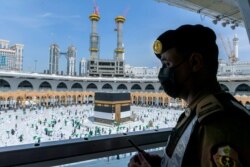 Petugas keamanan Saudi mengawasi jemaah haji mengelilingi Ka'bah, di Mekah, Arab Saudi, di tengah pandemi COVID-19. (AP)