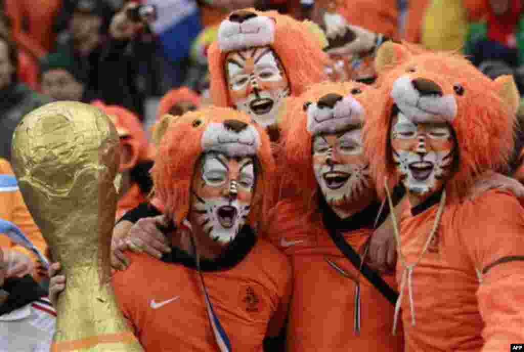 Netherlands supporters dressed as lions celebrate with a mock World Cup trophy at the end of the World Cup semifinal soccer match between Uruguay and the Netherlands at the Green Point stadium in Cape Town, South Africa, Tuesday, July 6, 2010. Netherlands