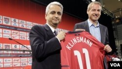 Juergen Klinsmann (kanan) tersenyum setelah diperkenalkan sebagai pelatih kepala tim sepakbola AS oleh Presiden U.S. Soccer Sunil Gulati dalam konferensi pers di New York, Senin (1/8). Tim AS di bawah Klinsmann akan menghadapi Meksiko dalam laga persahaba