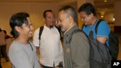 Reformed militants, from left to right, Zaenal Muttaqin, Toni Togar, Reza Sungkar, and Ramli, chat on the sidelines of a meeting with victims of attacks in Jakarta, Indonesia, Monday, Feb. 26, 2018.